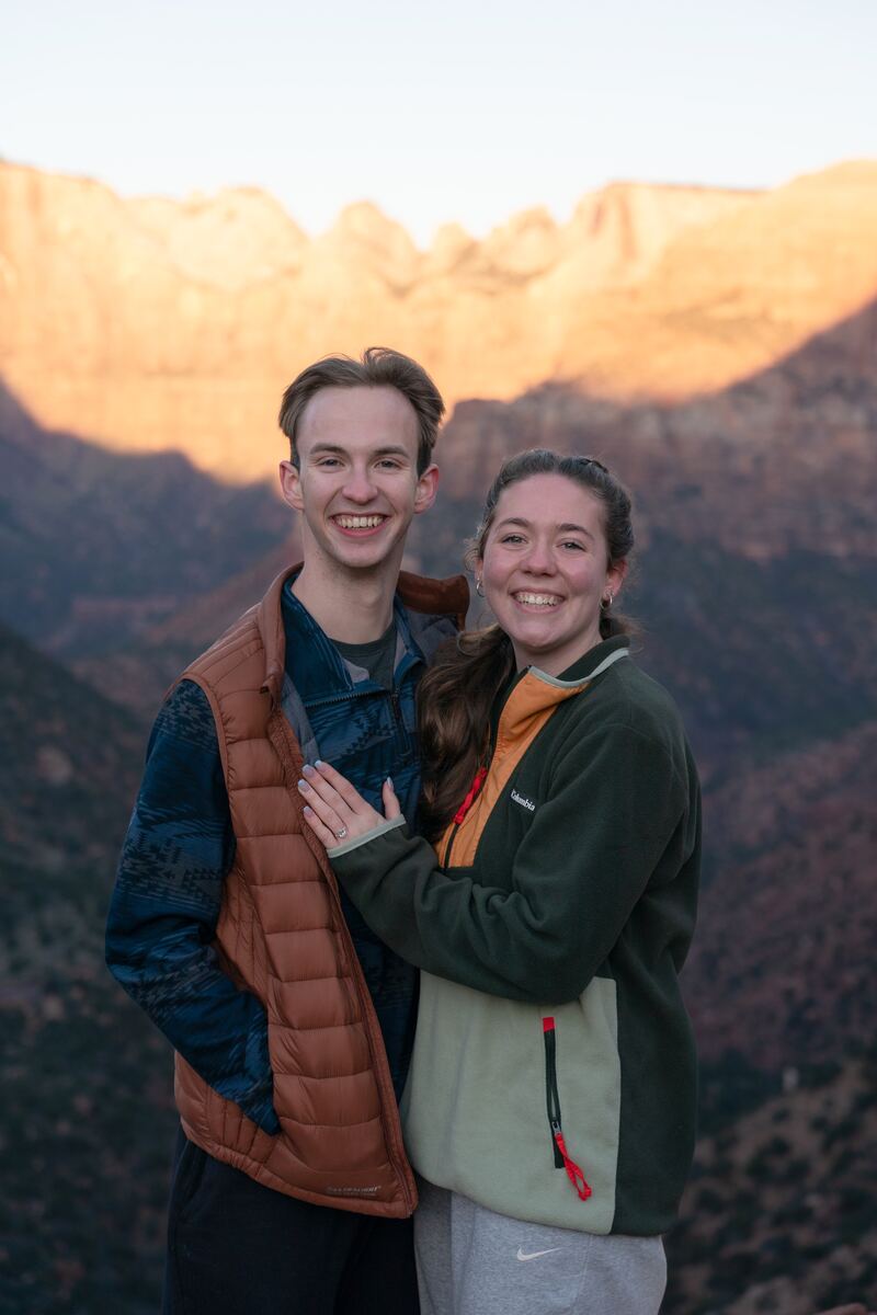 Engaged couple in front of the red cliffs of Zion
