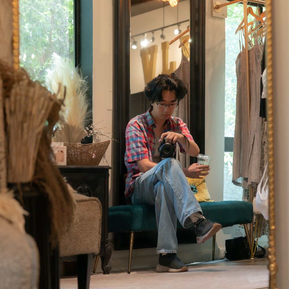 Zehao Xue in a shop mirror, camera in hand